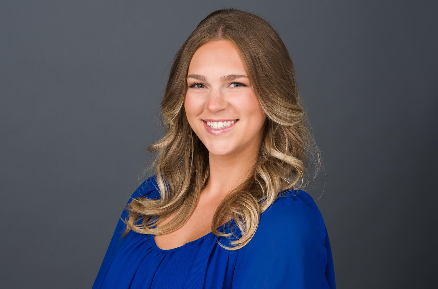 Professional Headshot Corporate headshot of young smiling female professional in blue blouse with blonde hair by Tampa photographer Sidney Oster