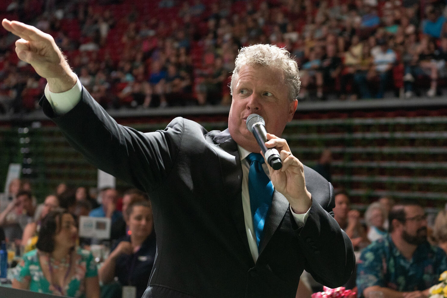 Auctioneer pointing and taking bids at corporate charity auction event